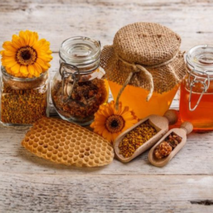 Image of natural sweeteners honey, , agave nectar in jars and, ground cinnamon, brown sugar and stevia in wooden scoops on wood table background