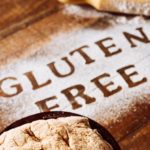 Image of the words "GLUTEN FREE" spelled out in gluten-free flour on a wood cutting board ppma