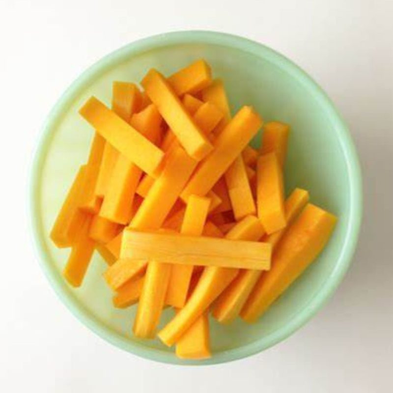 Image of uncooked butternut squash cut into fry shapes in a light green bowl to promote healthy recipes nutritionist-approved ppma