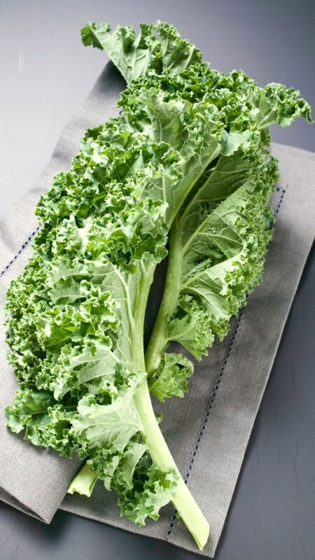 Image of large kale leaf on wooden board for a healthy recipe for PPMA private physicians medical associates