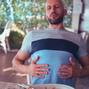 Image of a man feeling full and holding his belly after a large meal circadian rhythm PPMA private physicians medical associates
