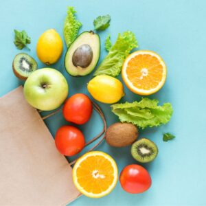 Image (flat lay) of brown paper bag with healthful nutritious produce at the top on a blue background PPMA private medical associates