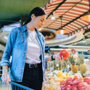 Image of woman shopping for tomatoes at the supermarket or grocery store for eating healthy on a budget PPMA private physicians medical associates