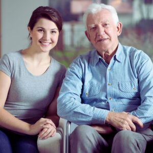 Image of smiling young woman caretaker granddaughter with older smiling man in wheelchair. PPMA private physicians medical associates