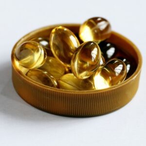 Image of mustard-brown vitamin bottle cap containing amber-colored fish oil gel caps. ppma private physicians medical associates