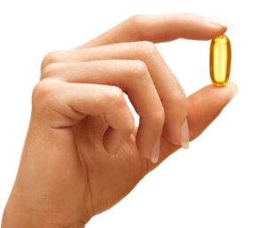 Image of hand holding a amber colored gel vitamin between first finger and thumb. ppma private physicians medical associates