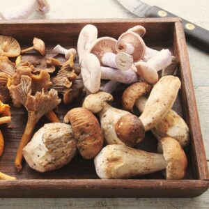 Image shows a wooden tray filled with a variety of mushrooms. Private Physicians Medical Associates. PPMA.