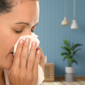 Image of a person blowing their nose with room in the background. PPMA. Private Physicians Medical Associates
