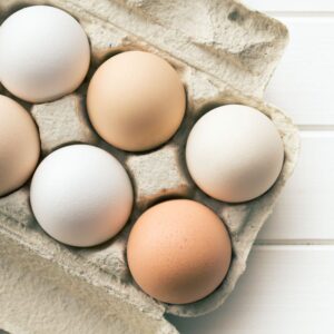 This is an image of a cardboard carton of eggs - three white, three brown.
