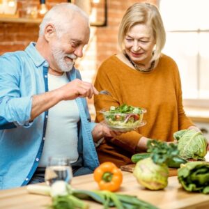An image of a middle-aged couple preparing a healthy salad together in their kitchen. The Art of Aging Well. PPMA