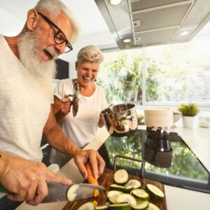 Exercise and Healthy Skin - an image of a happy couple smiling and laughing as they prepare a meal together.