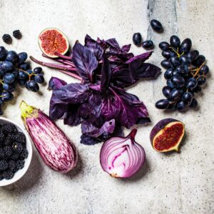 Am image of purple grapes, blueberries, blackberries, purple cabbage, eggplant, and other blue/purple fruits and vegetables.