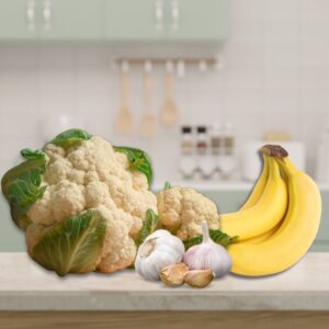 An image of a head of cauliflower, a bunch of bananas, and several garlic cloves.