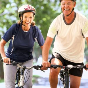 Image of woman and man riding bikes, both wearing helmets. Healthy weight.