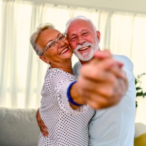 A happy couple dancing together in their home. Dance Like You’re Not Aging – The Art of Aging Well