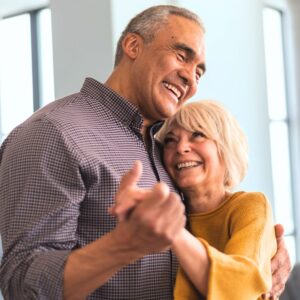 An image of a middle aged or senior couple smiling and dancing in each other's arms. Dance Like You’re Not Aging – The Art of Aging Well