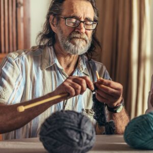 An older man is knitting. Making Art and The Art of Aging Well