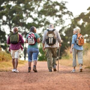 An image from behind of a group of four senior or middle-aged friends on a hike.