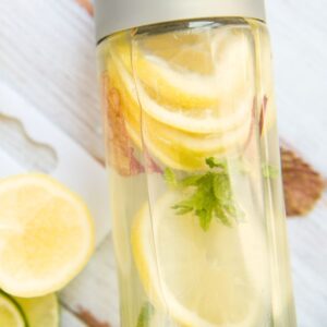 Hydration - a glass water bottle with lemon, mint, and water. Summer Road Trip Guide: Healthy Travel Tips