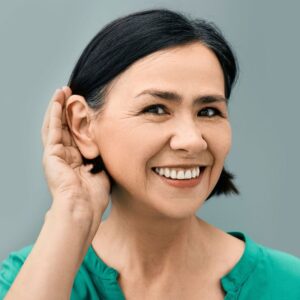 Image of a woman cupping her hand to her ear so that she can hear better. Protect your hearing