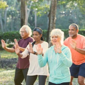 An image of a mixed group of adults practicing Tai Chi in a park. Balance Train to Avoid Falls