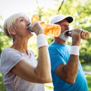 An image of a woman and a man, each drinking from a water bottle. hydration.