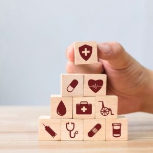 An image of beige building blocks with healthcare-related icons painted on them. Redefining Healthcare: Experience Concierge Medicine with a Caring and Supportive Team