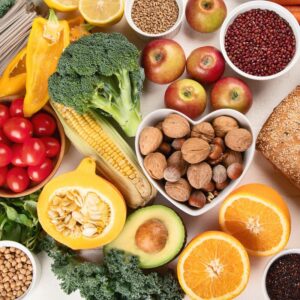 An image of high-fiber foods, including nuts, seeds, oranges, avocado, squash, apples, broccoli, and more. Gut health.