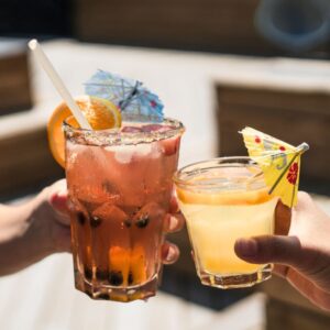 An image of people clinking their mocktail glasses together. Happy holidays! 