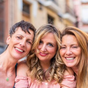 Support system - three middle-aged women friends pose together, smiling
