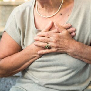 Woman feeling palpitations or other symptoms of heart disease.
