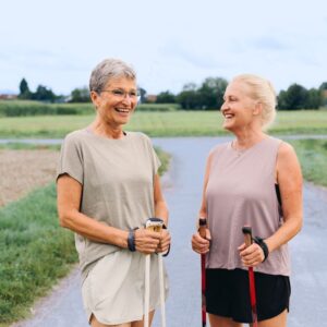 An image of two middle-aged women with walking sticks on a hike outdoors. Spring Into Physical Activity