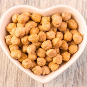 Chickpeas in white heart-shaped bowl.