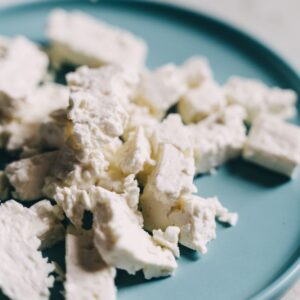 Feta cheese on blue plate. High-protein summer salad.