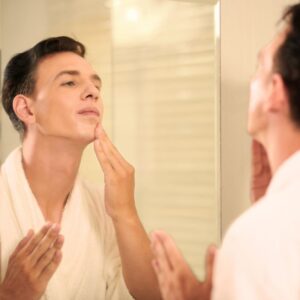 Man soothing his skin with cream.