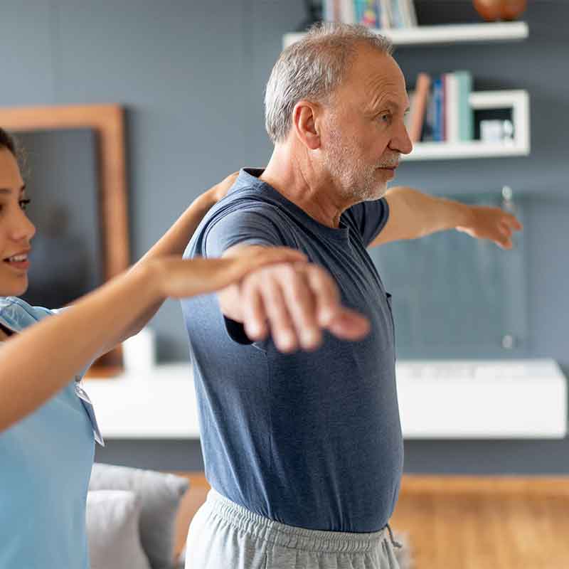 An image of an older man and a younger man practicing balance through yoga.