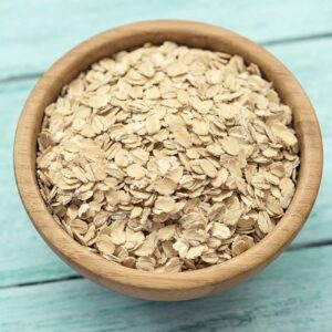 Close-up of old-fashioned rolled oats in a wooden bowl
